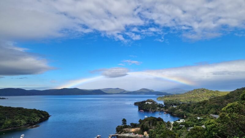 Blick vom Observation Rock auf Stewart Island mit Regenbogen in den Bergen