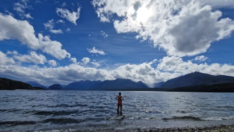 Kurze Erfrischung im Lake Manapouri mit Blick auf die Fjordlandschaft